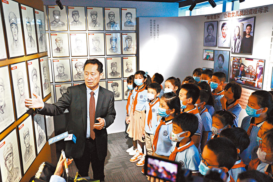 ●林宇輝用自己所畫的革命烈士的畫像向前來參觀的小學生講述革命烈士的英勇故事。受訪者供圖