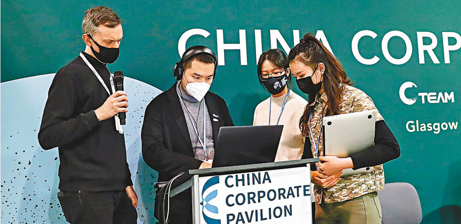 ●當地時間10日，中國和美國在聯合國氣候變化格拉斯哥大會期間發布《中美關於在21世紀20年代強化氣候行動的格拉斯哥聯合宣言》。圖為格拉斯哥中國企業館，志願者張如苑（右二）協助工作人員調試設備。張如苑是英國帝國理工學院流行病專業碩士，大會期間負責布置會場、前台接待、會議記錄、新聞稿撰寫等工作。  新華社