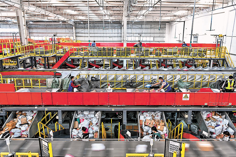 ● 廣州迎來「雙11」快遞高峰，順豐番禺化龍分撥中心工作人員將快遞包裹放入分撥傳送帶上。  中新社