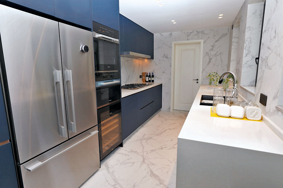 ● 廚房以貴族藍的膠板與白色牆身做配襯，更顯時尚貴氣。