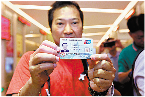 目前16萬港澳居民在內地參加養老保險。圖為港澳居民領取珠海社保卡。 資料圖片