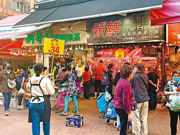 ●與黃元興相隔一個檔位的「領鮮新鮮豬肉專門店」，貼出黃底紅字的「豬骨瘦肉$34」告示。 香港文匯報記者  攝