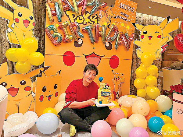 ● 黃曉明手捧比卡超蛋糕拍照。