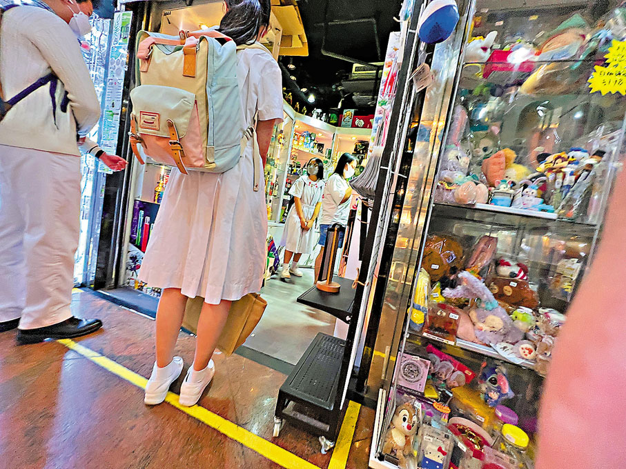 ● 身校服的學生出入CBD專門店。香港文匯報記者 攝