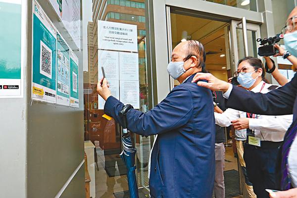 ●詹培忠進入法庭前使用「安心出行」。香港文匯報記者  攝