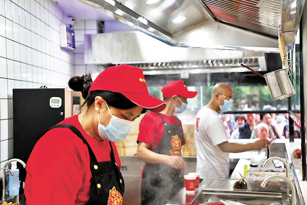 ● 林金斌標準店的廚房直觀透明，服務員在有條不紊地忙碌着。