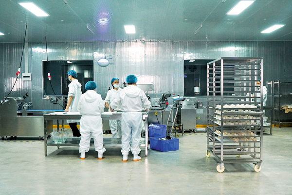 ● 加工車間中，工人們戴着口罩，身着全套潔淨服在流水線上忙碌。