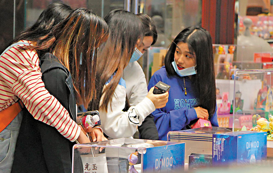 ●一群年輕女孩在挑選盲盒。