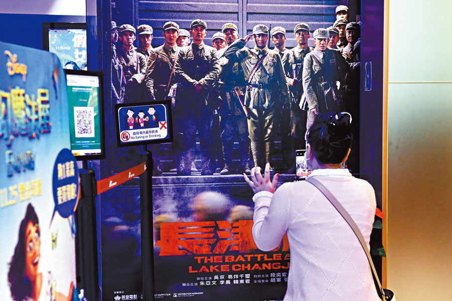 ● 香港有市民於貼有《長津湖》電影海報的電影院外拍照留念。  中新社