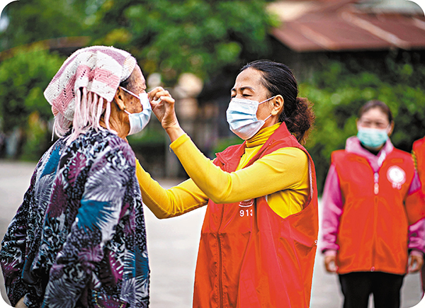 ●瑞麗市姐相鄉弄換村民小組的巡護隊幫助村裏的老年人正確佩戴口罩。資料圖片