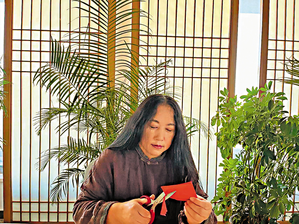 ●吉林省工藝美術家李寶鳳沉醉於剪紙創作裏。 香港文匯報記者盧冶 攝