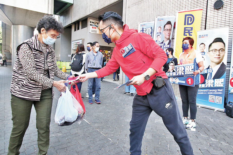 ● 梁熙(右)向街坊拉票。 香港文匯報記者  攝