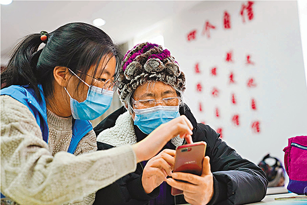 ●內地採取不同方式幫助長者使用「健康碼」，專家倡港效仿。圖為北京市志願者為老人講解如何使用智能手機查詢健康碼。 資料圖片