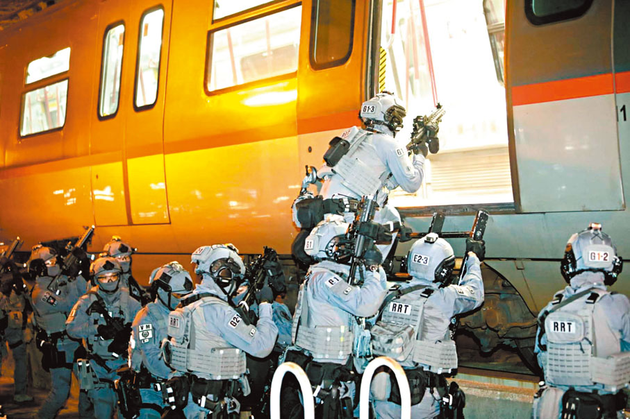 ●一隊全副武裝鐵路應變部隊人員在代號「風行」的反恐演習中，模擬由路軌進入港鐵車廂。 警方圖片