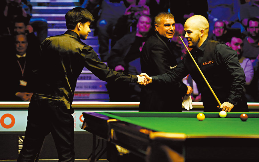 ●趙心童（左）與比素爾握手致意。  新華社