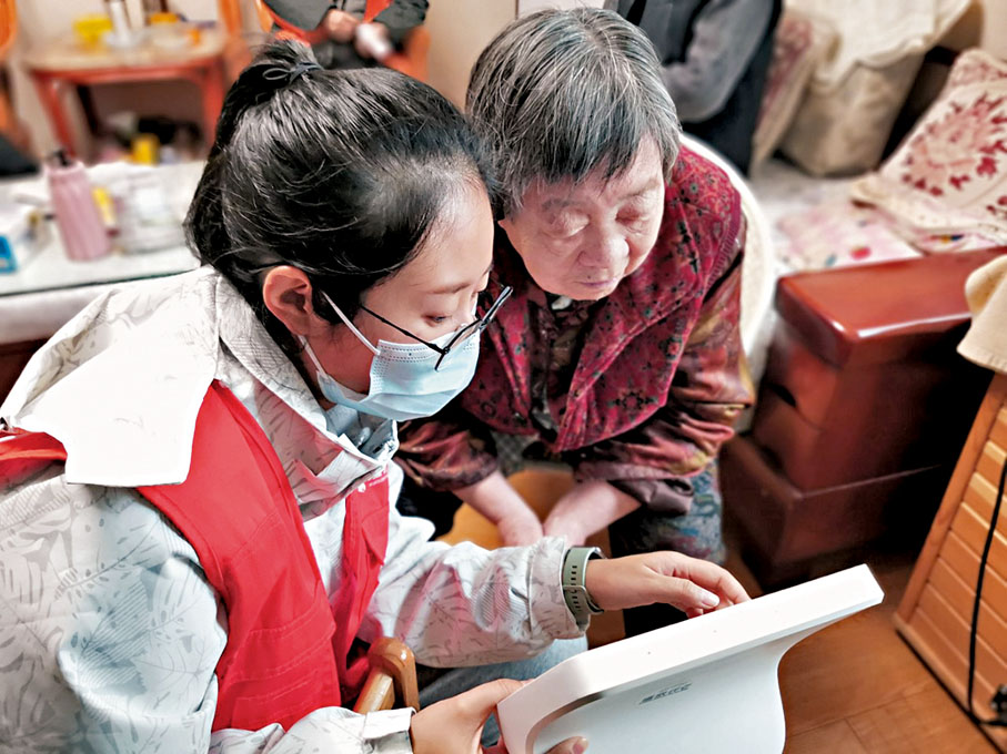 ● 工作人員上門為老人講解智能機器人用法。