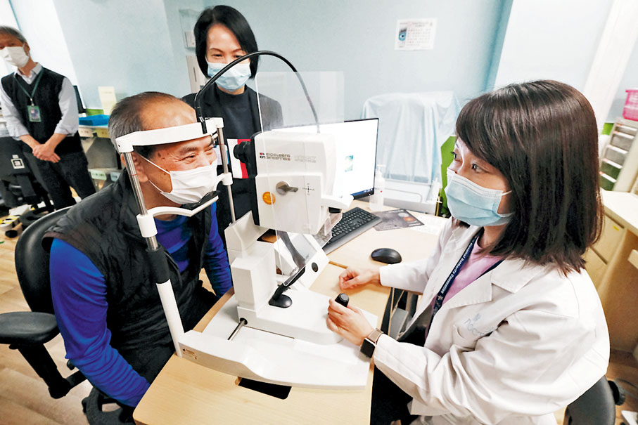 ●港島東醫院聯網眼科部門主管高嘉莉與白內障患者吳先生示範眼科診斷過程。 香港文匯報記者 攝