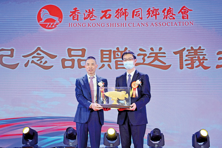 ● 石獅市委書記黃春輝（右）向第十五屆蔡佳定會長贈送紀念品。