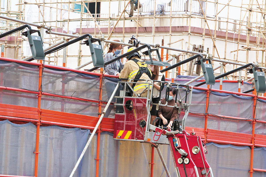 ●消防架設雲梯救援5樓平台被困市民。香港文匯報記者 攝