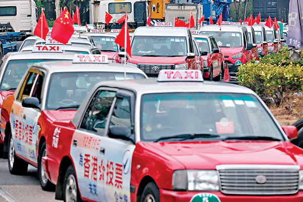 ●「的總」500部的士貼上海報、掛國旗巡遊，呼籲市民投票。 香港文匯報記者  攝