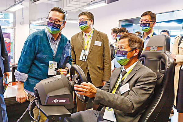 ● 中學校長試玩數碼港初創公司Formula Square研發的 5G遙控賽車。