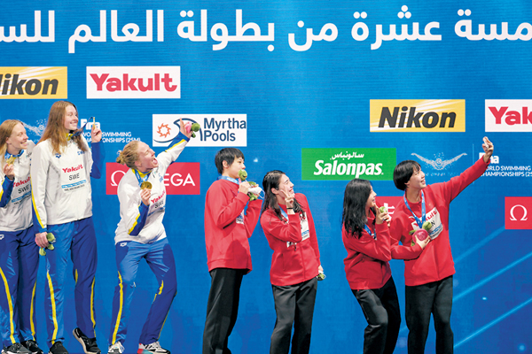 ● 彭旭瑋（右一）、唐錢婷（右二）、張雨霏（右三）和程玉潔（右四）在領獎台上合影。  新華社