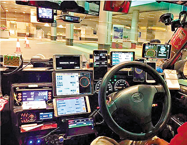 ● 目前不少的士司機車頭擺放多部手機用作接單。 fb圖片
