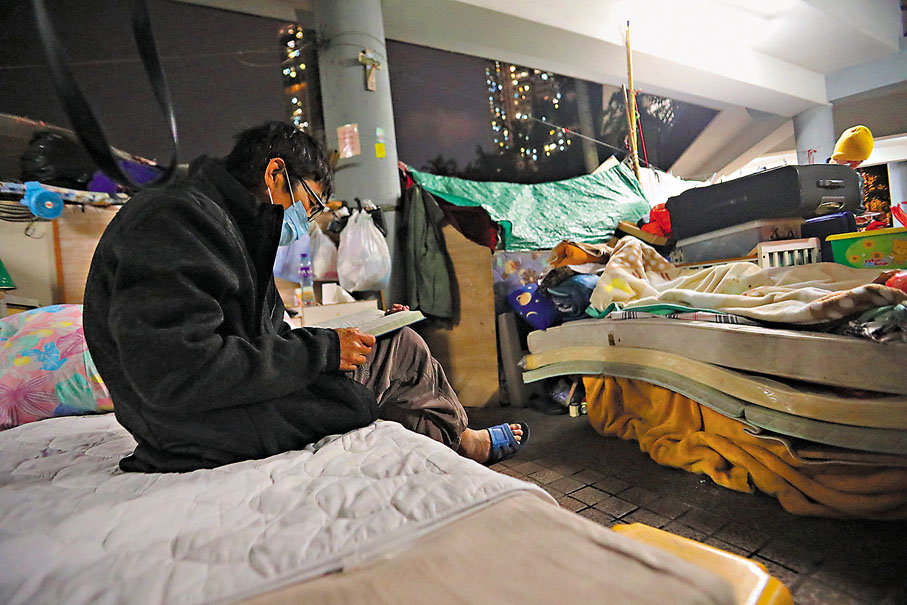 ●無家者景哥手捧越南文和英文的聖經在閱讀，寒冷與窮困不滅他的信仰熱誠。香港文匯報記者 攝