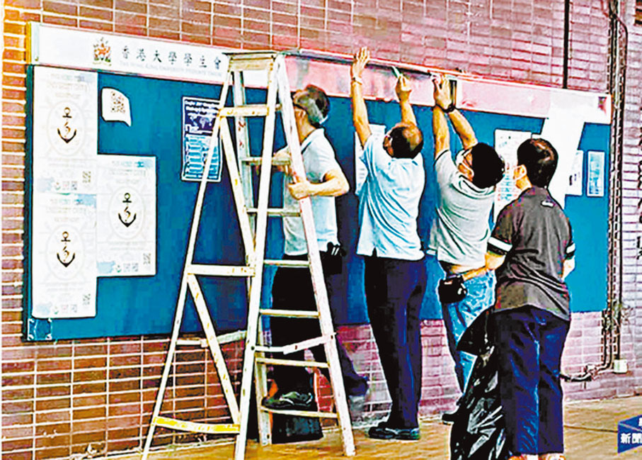 ●港大職員移除學生會標誌。 資料圖片