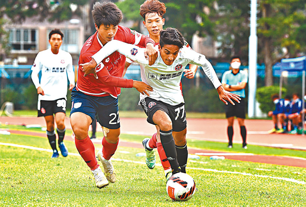 ◆東方龍獅隊球員王力威（右）帶球突破香港U23隊球員陳潤潼的攔截。  新華社