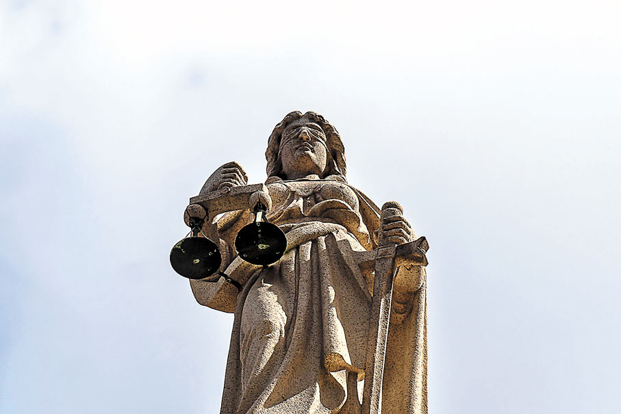 ◆ 正義女神永遠蒙着眼睛，象徵法律面前，人人平等。圖為香港終審法院上的正義女神雕像。 資料圖片