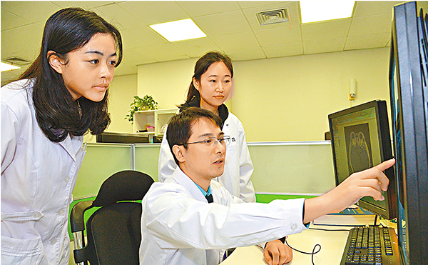 南京醫科大學第一附屬醫院放射科教授、副主任醫師王守巨（中）和團隊成員在做研究。 受訪者供圖