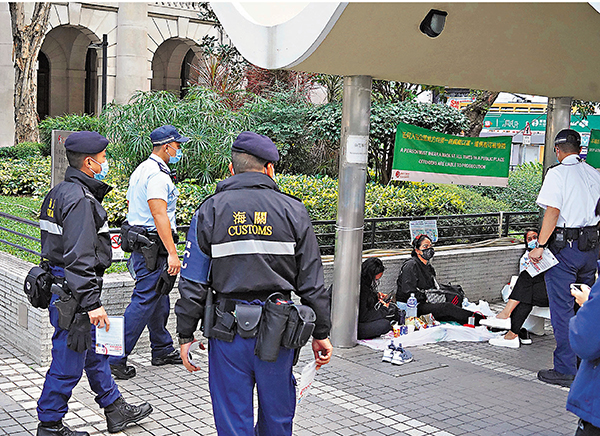 ◆巡邏人員提醒外傭遵守防疫規例。 香港文匯報記者  攝