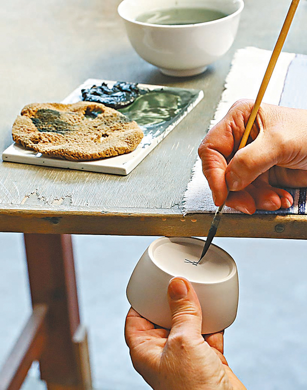 ◆在德國邁森瓷器工坊內，工作人員在瓷器上繪製標識。