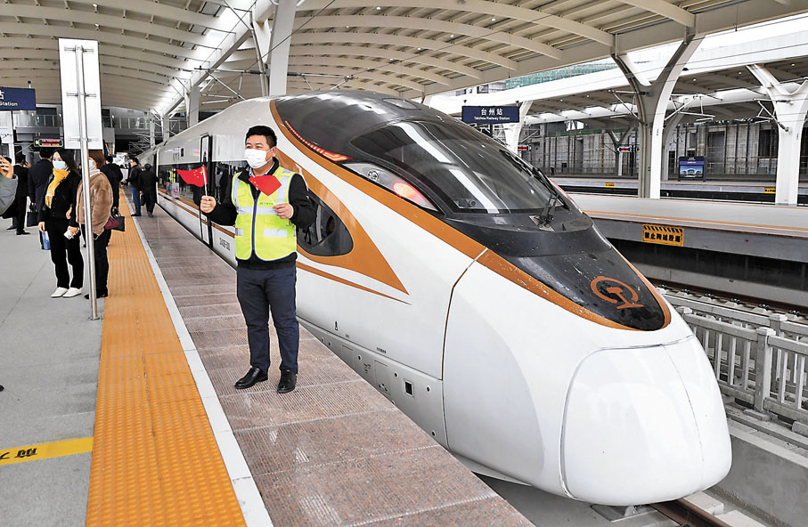 ◆8日，鐵路工人在台州站與杭台高鐵首發列車合影。 中通社