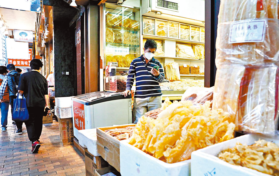 ◆店舖生意冷清，職員睇手機打發時間。香港文匯報記者  攝