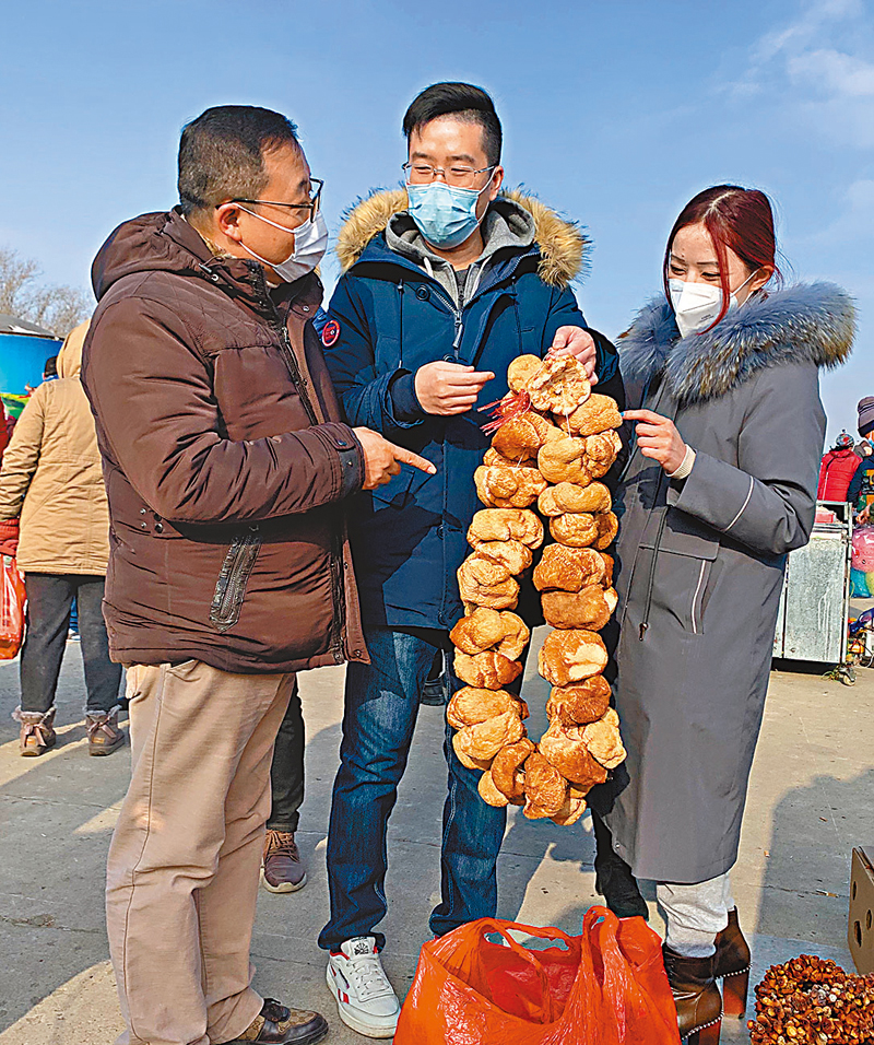 ◆林競秀（右）和港人朋友被祝家大集上巨大的乾猴頭菇吸引。