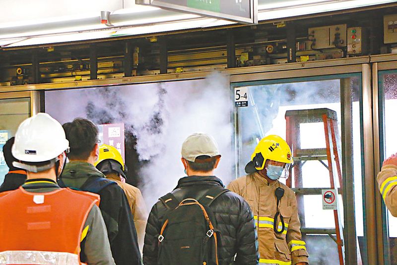 ◆ 港鐵人員在發生火警的幕門檢查，消防員到場向天花噴滅火噴霧。