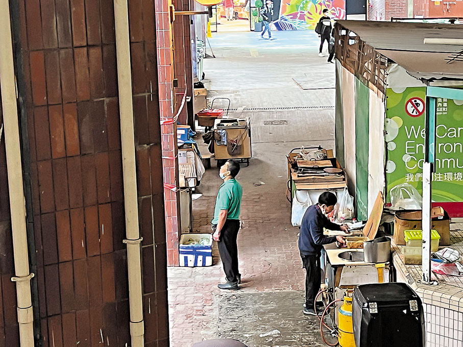 ◆利東邨垃圾房外，一名清潔工前來與小販交涉，二人均未戴口罩。香港文匯報記者  攝