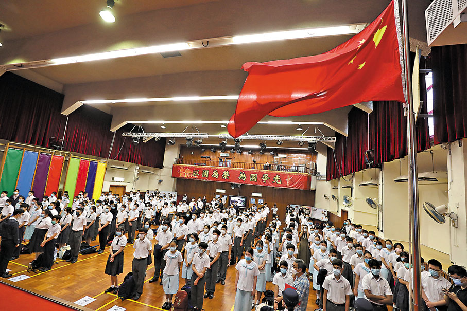 ◆ 陳學鋒憶述，曾在初中擔任持旗手，「十一」國慶時，在老師同學見證下升起國旗、同唱國歌，至今仍感受到那份光榮。圖為一所本地中學的升國旗儀式。 資料圖片