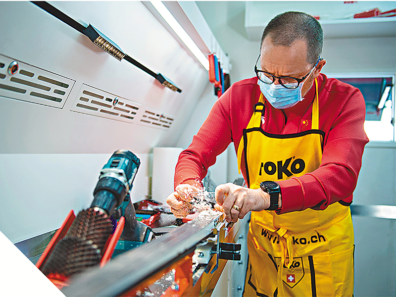 外籍打蠟師在雪蠟車內為滑雪板打蠟。  資料圖片