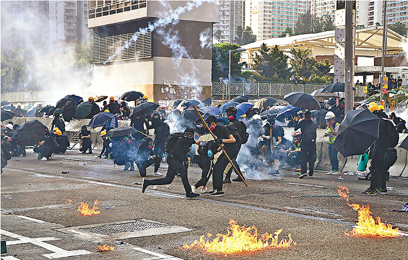 ◆2019年10月1日，黃大仙發生暴亂，被捕12名被告中，11人昨日在區域法院被裁定暴動罪成。圖為當日有暴徒向警員投擲燃燒瓶及磚塊。 資料圖片