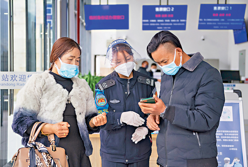 ◆春節臨近，在雲南小灣東站，旅客向工作人員出示健康碼。 新華社