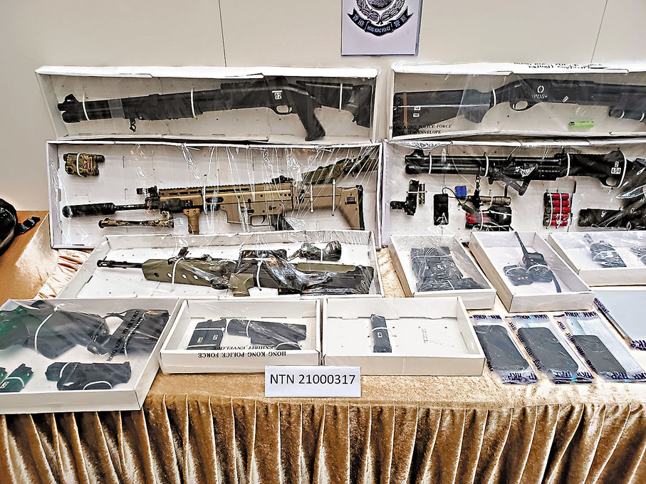 ◆海關指國安法實施後，2021年查獲火器及彈藥案件數目明顯下降，較2020年大跌65%。圖為2021年海關及警方在記者會上展示檢獲的氣槍及無線電對講機等證物。資料圖片