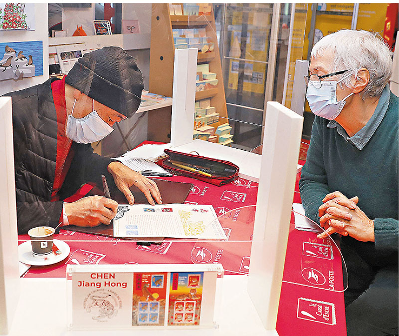 ◆藝術家陳江洪（左）在簽售虎年生肖紀念郵票。
