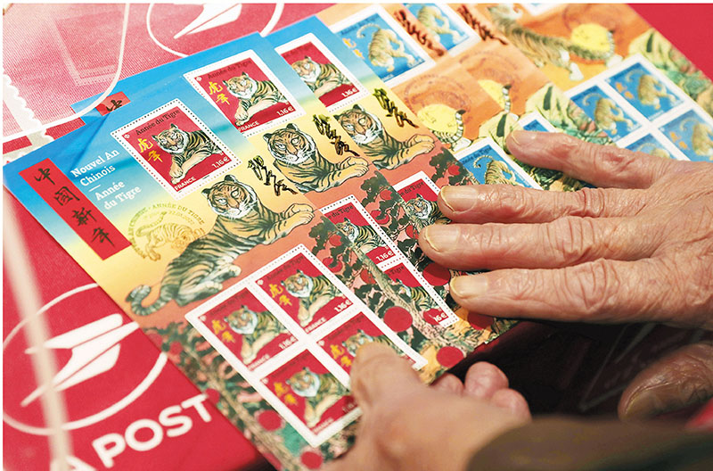 ◆一名集郵愛好者展示其購買的虎年生肖紀念郵票。