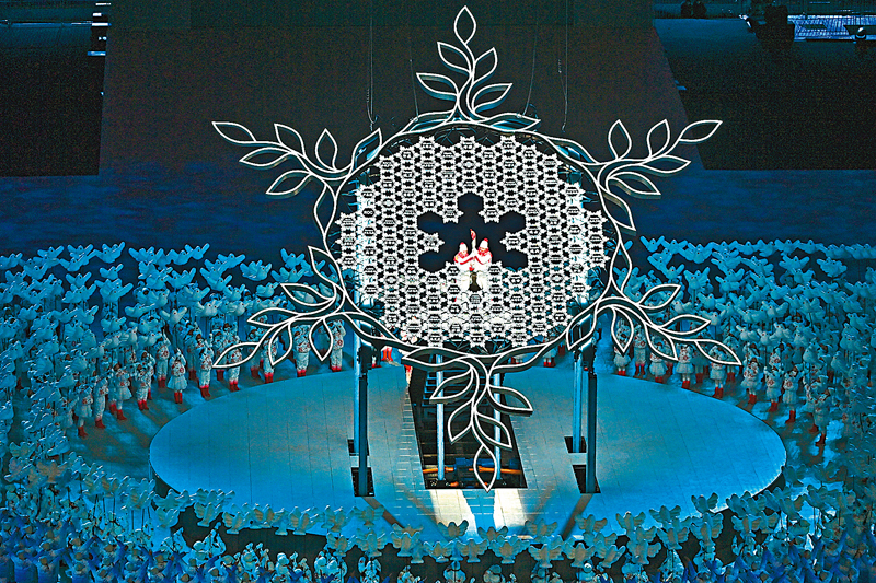 ◆2月4日晚，第二十四屆冬季奧林匹克運動會開幕式在北京國家體育場舉行。圖為兩位火炬手將最後一棒火炬留在「大雪花」中心。    中新社