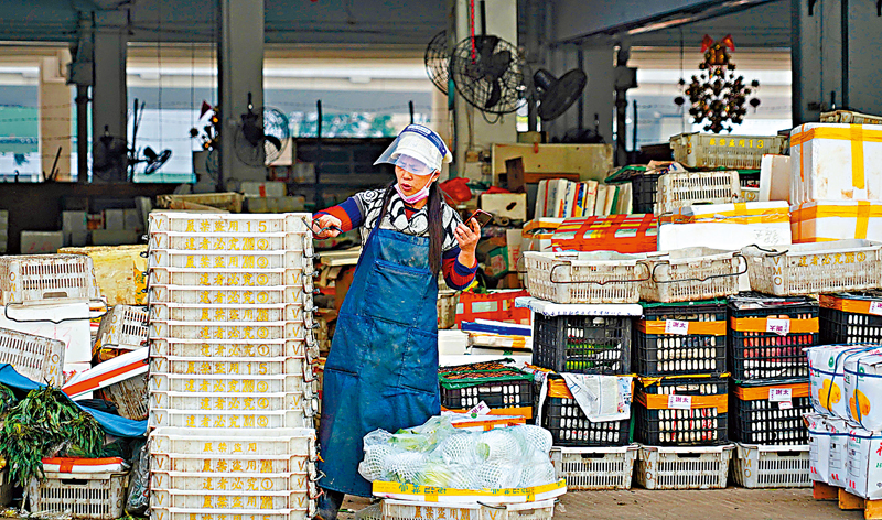 ◆ 市場內不時有員工除罩工作，而消息指市場爆疫源頭是一名菜商，他曾沒戴口罩在菜欄工作。香港文匯報記者  攝