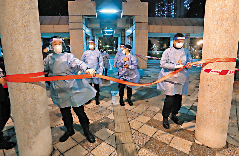 ◆特區政府昨晚圍封沙田利安邨利盛樓強制檢測，工作人員以膠帶進行封鎖。香港文匯報記者  攝