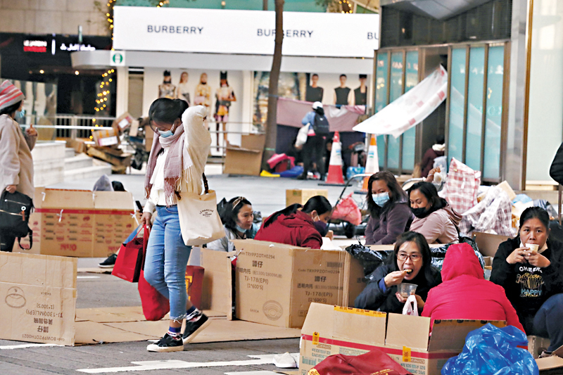 ◆有外傭昨在中環街頭聚集用膳，且普遍多於二人以上圍坐，無視二人限聚令。 香港文匯報記者  攝